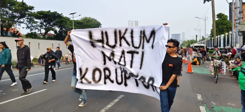 Massa aksi Aliansi Masyarakat Pati Bersatu (AMPB) membentangkan spanduk tuntutan saat demonstrasi di depan Gedung DPR mendesak pengesahan RUU Perampasan Aset.